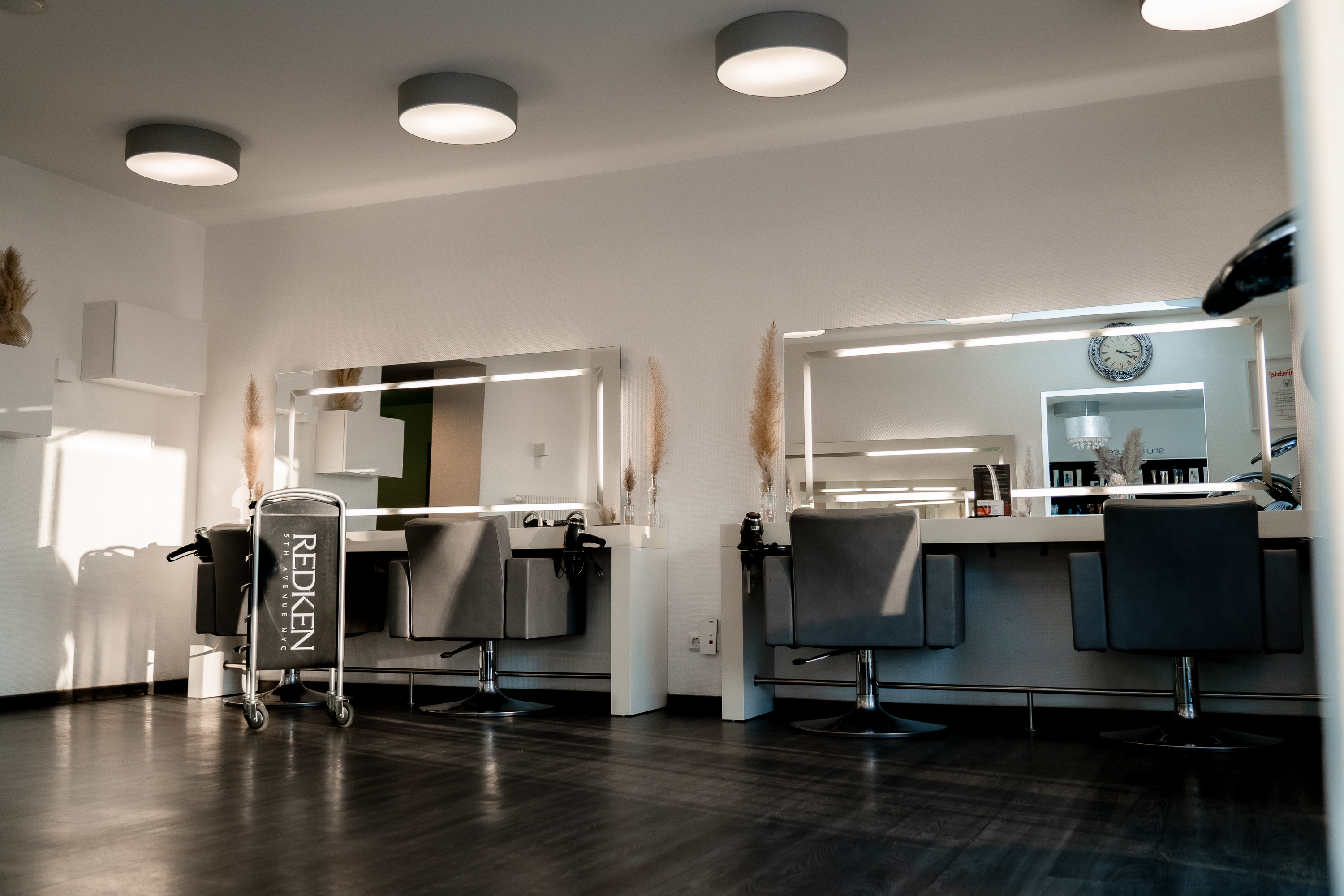 Stilvolle Arbeitsplätze mit beleuchteten Spiegeln im Friseursalon Ayhan, Blieskastel Saarland